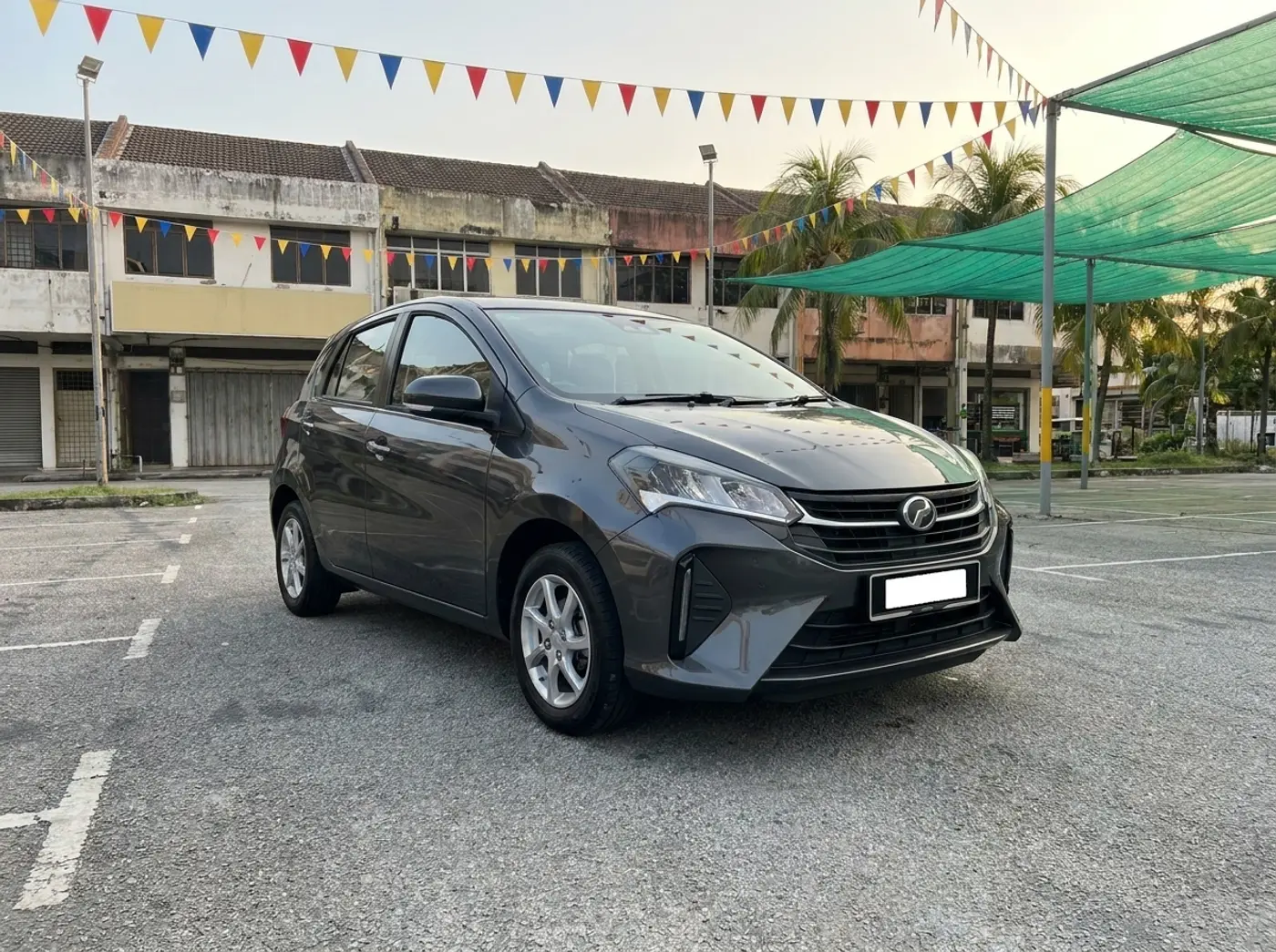 A granite grey Perodua Myvi on the KeretaKu Motors used-car lot in Cheras