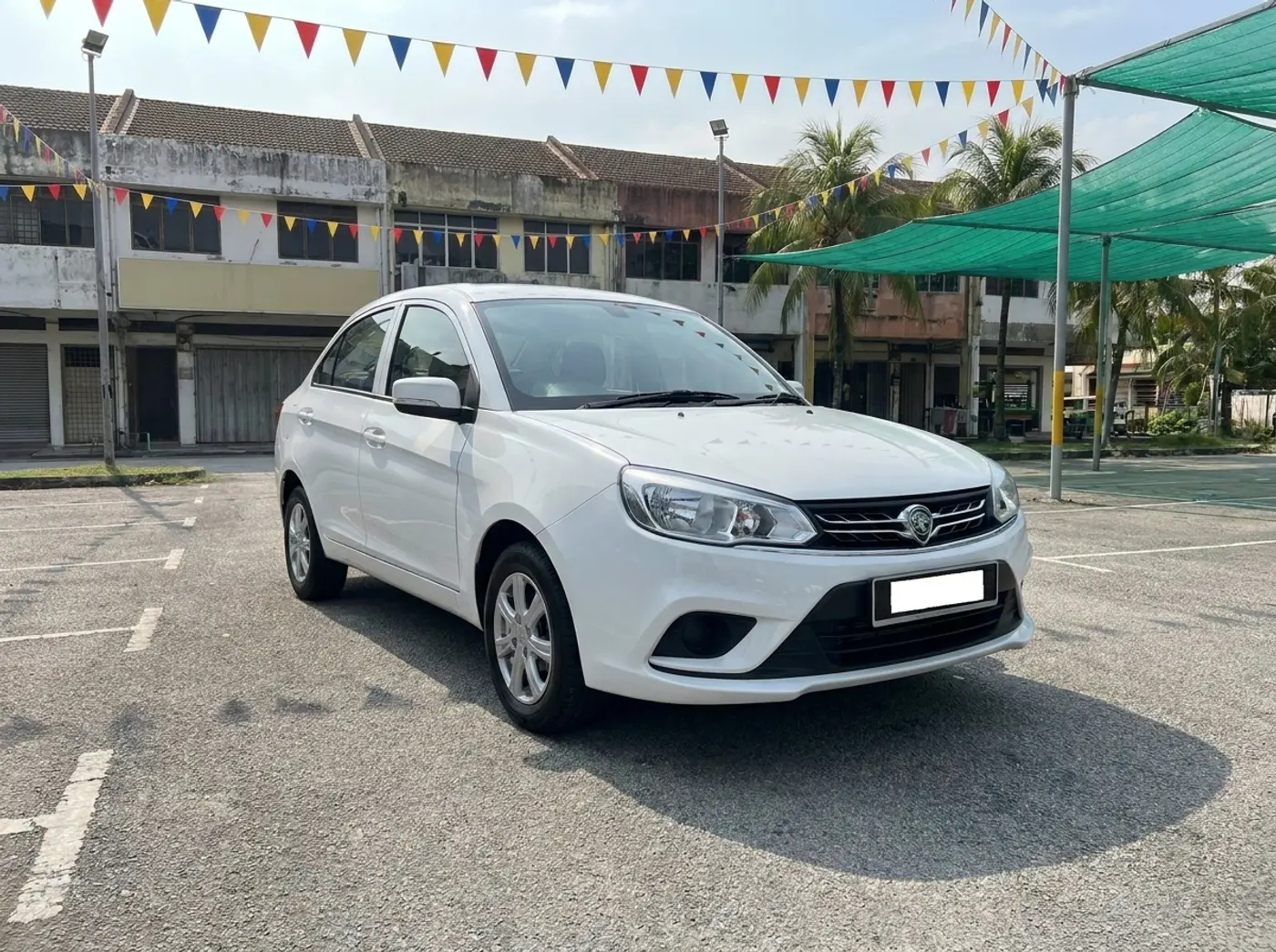 A white Proton Saga on the KeretaKu Motors used-car lot